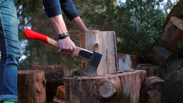 一个人正准备用斧子砍倒一根木头。视频素材