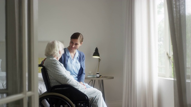看护者和坐在轮椅上的女人聊天视频素材