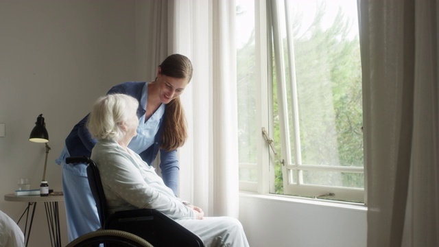 护工与坐在轮椅上的老妇人交谈视频素材