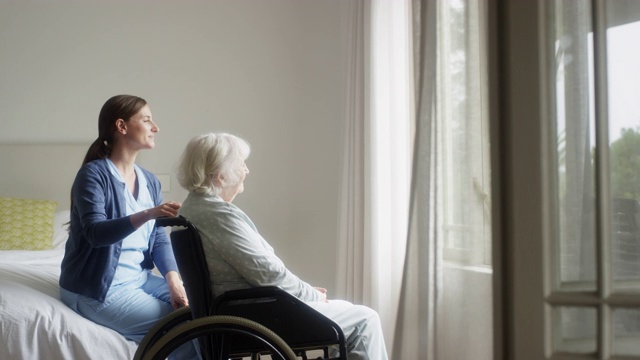 微笑的护士和老妇人透过窗户看视频素材