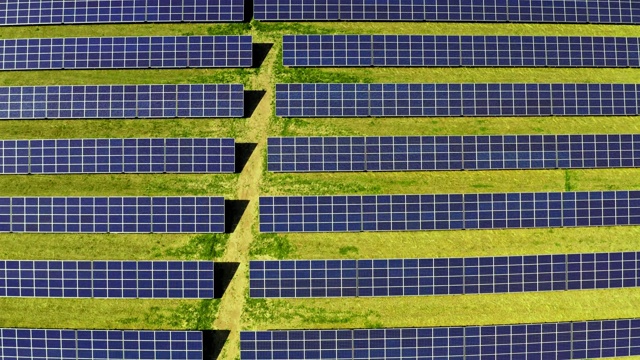 太阳能电池板在绿色的田野在夏天的俯视图视频素材