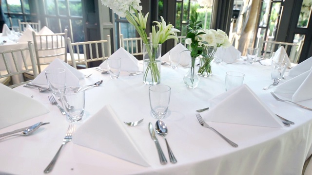 婚宴餐桌上为客人摆放鲜花和陶器。视频下载