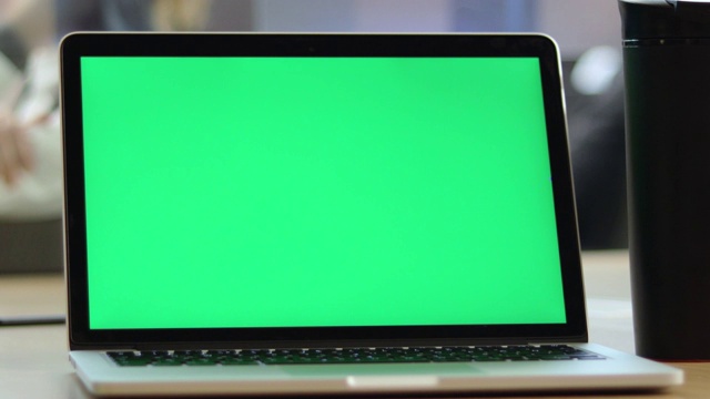 在办公室桌上使用彩色键屏笔记本电脑拍摄4K特写视频视频下载
