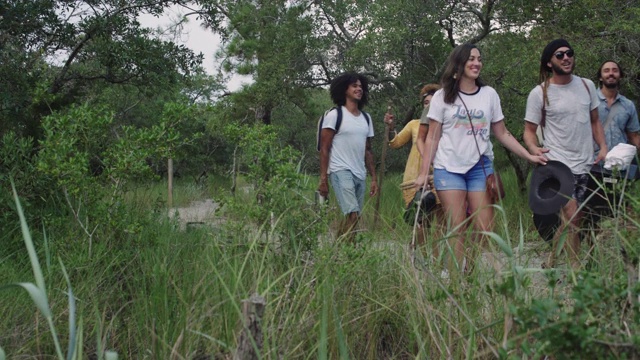 一群来自不同民族的朋友徒步穿越树林去野餐视频下载