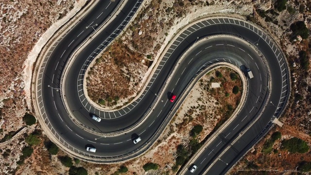 鸟瞰图上的汽车在一个曲折的道路形状为字母S视频下载