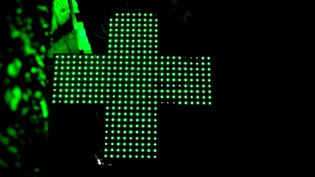 照明绿色医药十字。药房路标。视频下载