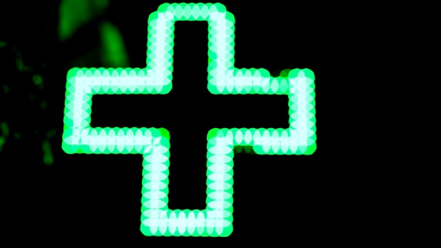 照明绿色医药十字。药房路标。视频下载