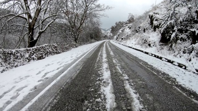 在冰雪覆盖的乡村道路上缓慢小心地行驶视频素材