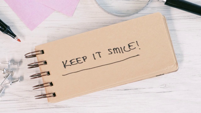 一个男人的手在办公室笔记本上写着“保持微笑”的4K视频视频下载