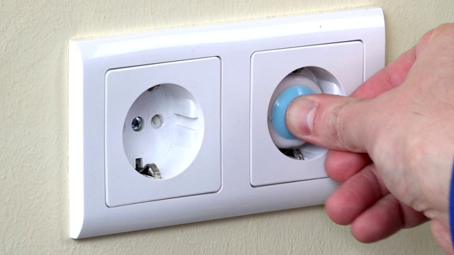 用手在墙上的电源插座上安装安全插头视频素材