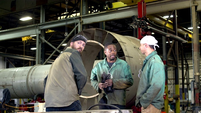 男人们在金属加工车间工作，开会视频素材