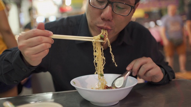 街头小吃-亚洲人在曼谷吃鸭肉面视频素材