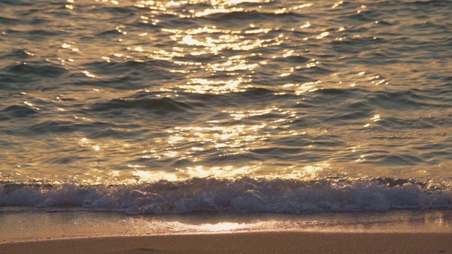 慢镜头泰国芭堤雅日落或日出时的金色反射波海滩视频素材