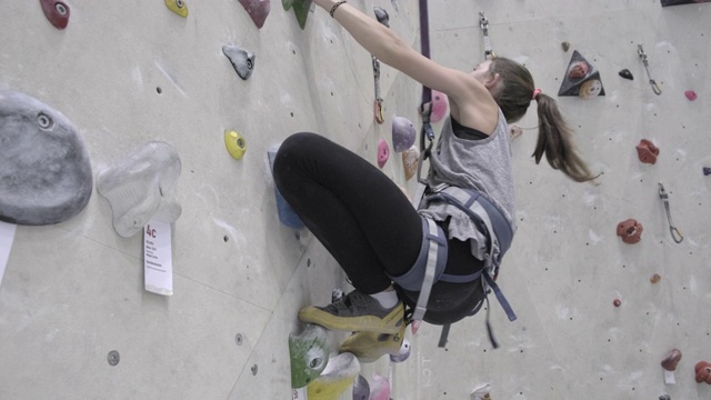 十几岁的女孩在爬室内攀岩墙视频素材