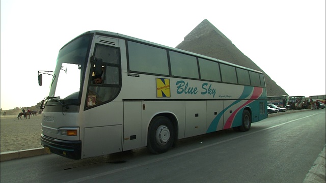 旅游巴士经过埃及吉萨的金字塔。视频下载