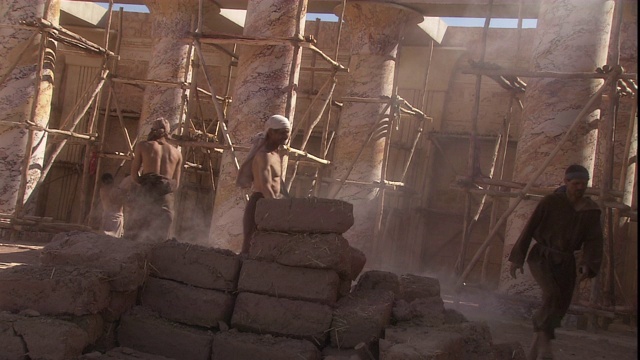 奴隶们在庙宇建筑工地搬运砖块。视频下载