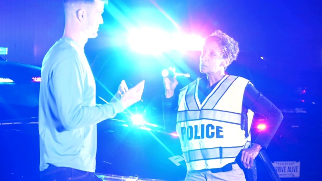 女警察在晚上和年轻男子谈话视频素材