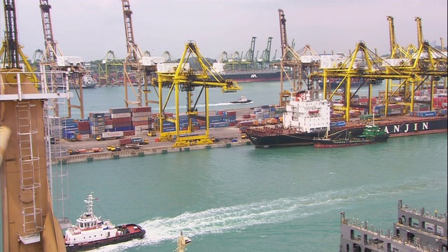 一艘船驶过集装箱码头和新加坡港的其他船只。视频下载