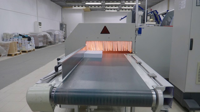 造纸生产线中的工业机器人。在工作中操作生产线机器。视频素材