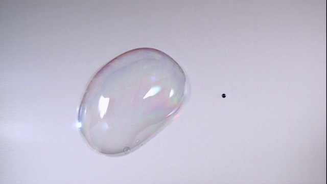 BB枪刺穿了一个泡泡，使它在慢镜头中破裂。视频素材