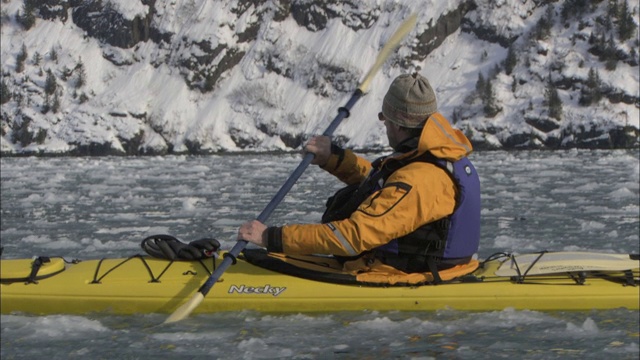 阿拉斯加，一名皮划艇手在冰冷的威廉王子湾划桨。视频下载