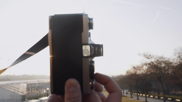 背光特写镜头，手握老式电影相机，日落巴黎埃菲尔铁塔在取景器慢动作。视频素材