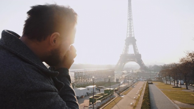 一名快乐的专业摄影师正在用老式相机慢动作拍摄巴黎埃菲尔铁塔的背光照片。视频素材