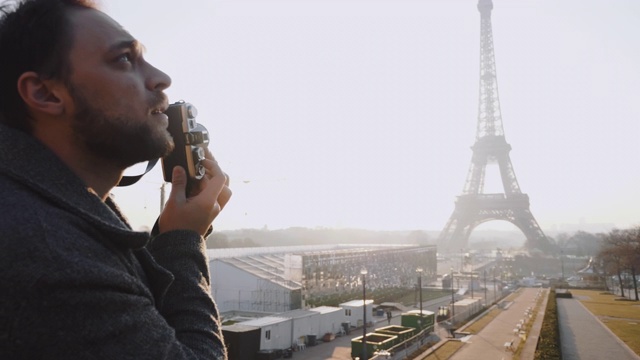 背景快乐的男性白人记者在巴黎用老式胶片相机拍摄埃菲尔铁塔的慢镜头视频素材