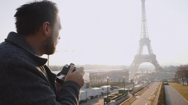 后视镜快乐的自由摄影师男子拍照的埃菲尔铁塔在巴黎与复古电影相机的慢动作。视频素材
