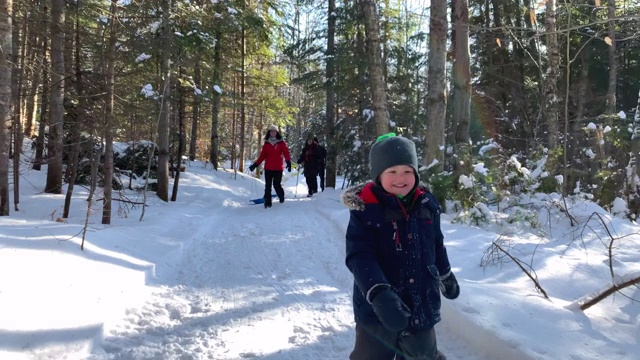 小男孩在冬天暴风雪后的森林里奔跑视频素材