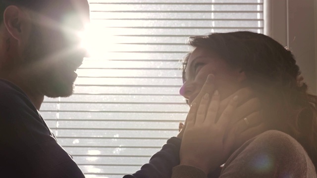 一对深情的情侣在阳光明媚的窗前享受甜蜜时光视频素材