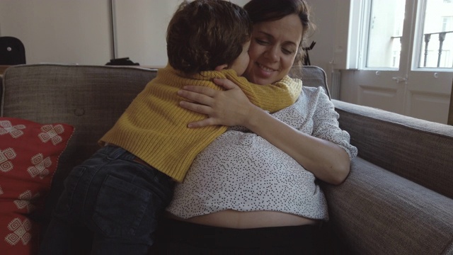 男孩摸着他怀孕的妈妈的肚子。缓慢的运动。视频素材