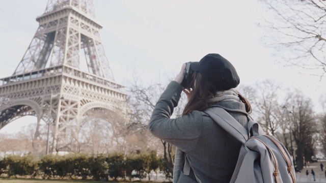 后视图快乐的自由摄影师女人拍下了埃菲尔铁塔在巴黎出差的慢动作。视频素材