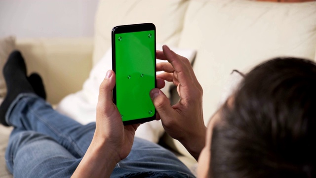 男人手里拿着智能手机的绿屏是绿屏，男人手里拿着智能手机的绿屏是带色度键的白背景，新技术概念视频素材