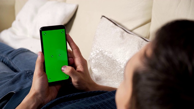 男人手里拿着智能手机的绿屏是绿屏，男人手里拿着智能手机的绿屏是带色度键的白背景，新技术概念视频素材