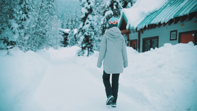 亚洲女人行走在白雪覆盖的森林里视频素材