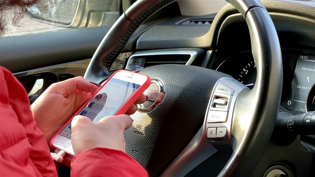 一名女性在开车时使用智能手机。视频素材