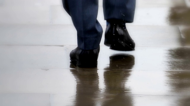 聪明的城市鞋，商人在雨中行走。只放脚，后视图。视频下载