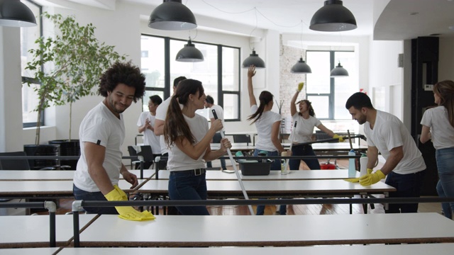 拉丁美洲的保洁人员在办公室边唱歌边跳舞边微笑着打扫办公室视频素材