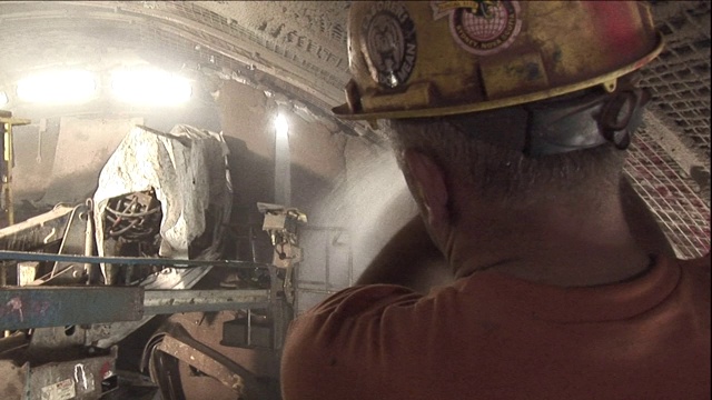 一名建筑工人用水管冲洗尼亚加拉隧道中的设备。视频素材