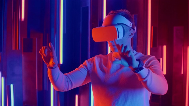 年轻人在霓虹灯下戴上VR头盔视频素材