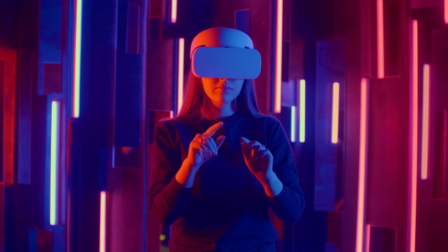 戴着VR头盔的年轻女子环顾四周，惊叹不已。虚拟现实头盔。视频素材
