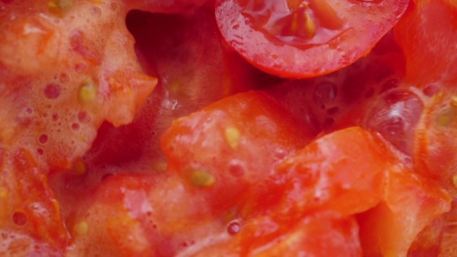 在搅拌机里放入番茄片。缓慢的运动。特写镜头。视频素材