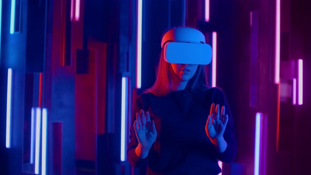 戴着VR头盔的年轻女子环顾四周，惊叹不已。虚拟现实头盔。视频素材
