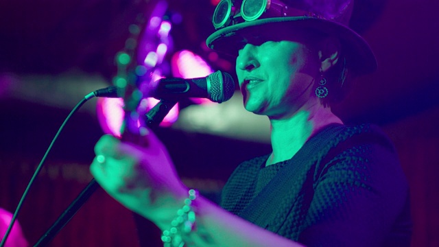 这位45岁的成熟女性、音乐家兼歌手的视频形象，穿着蒸汽朋克服装、戴着帽子、戴着眼镜视频素材