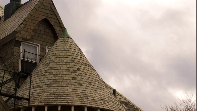 阴沉的天空勾勒出罗得岛州一座锥形屋顶的房子的轮廓。视频下载