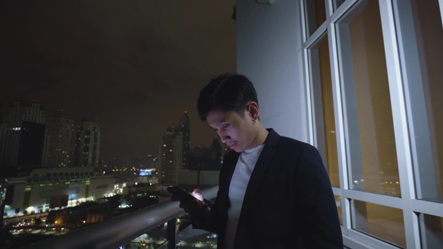 男人在晚上下班后查看智能手机视频素材