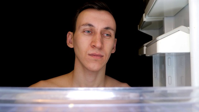 瘦饥饿的男人打开冰箱寻找食物特写视频下载