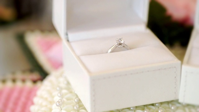 漂亮闪亮的结婚戒指和白色的盒子给新郎和新娘。视频素材