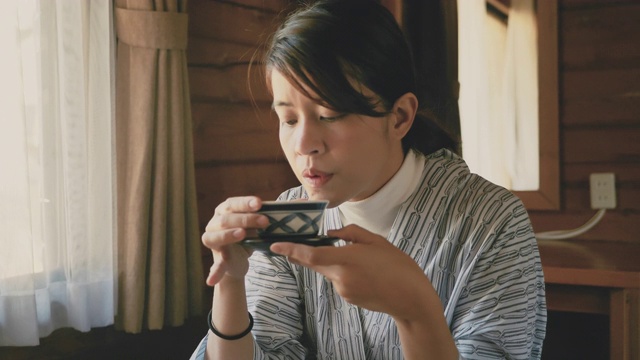 年轻的亚洲女人喝热茶仪式视频素材